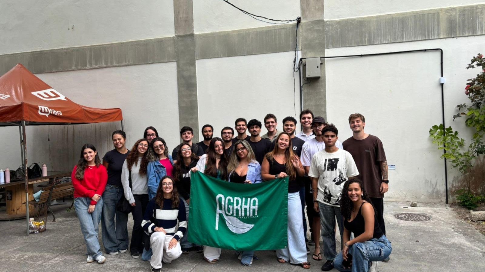Equipe AGRHA Consultoria 2026.1 reunida com a bandeira da empresa